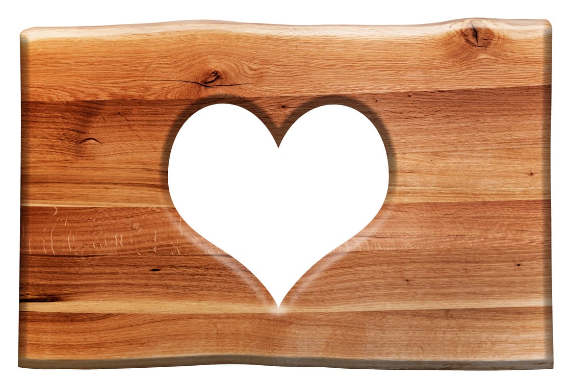 a wooden cutting board with a heart cut out of it