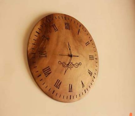 a wooden clock with roman numerals on the face