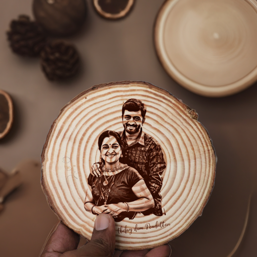 a hand holding a wood slice with an image of a couple